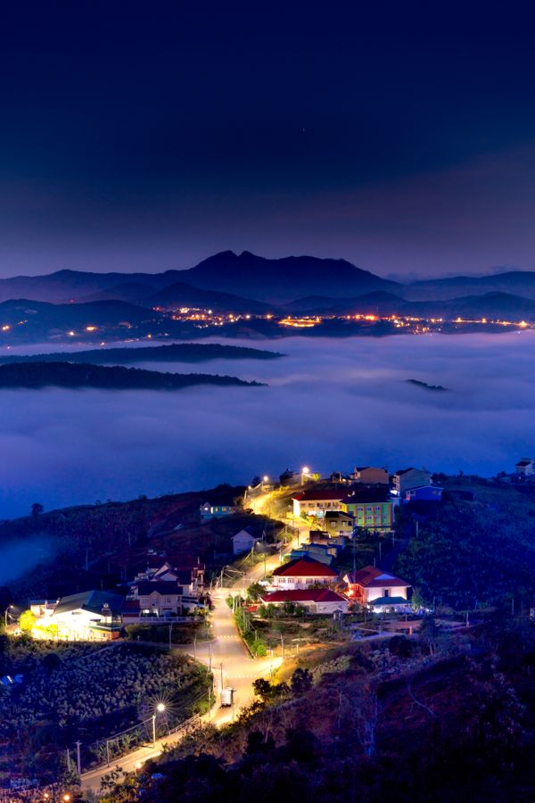 Aerial view of a hillside village above low cloud at night, photo by Quang Nguyen Vinh on Pexels