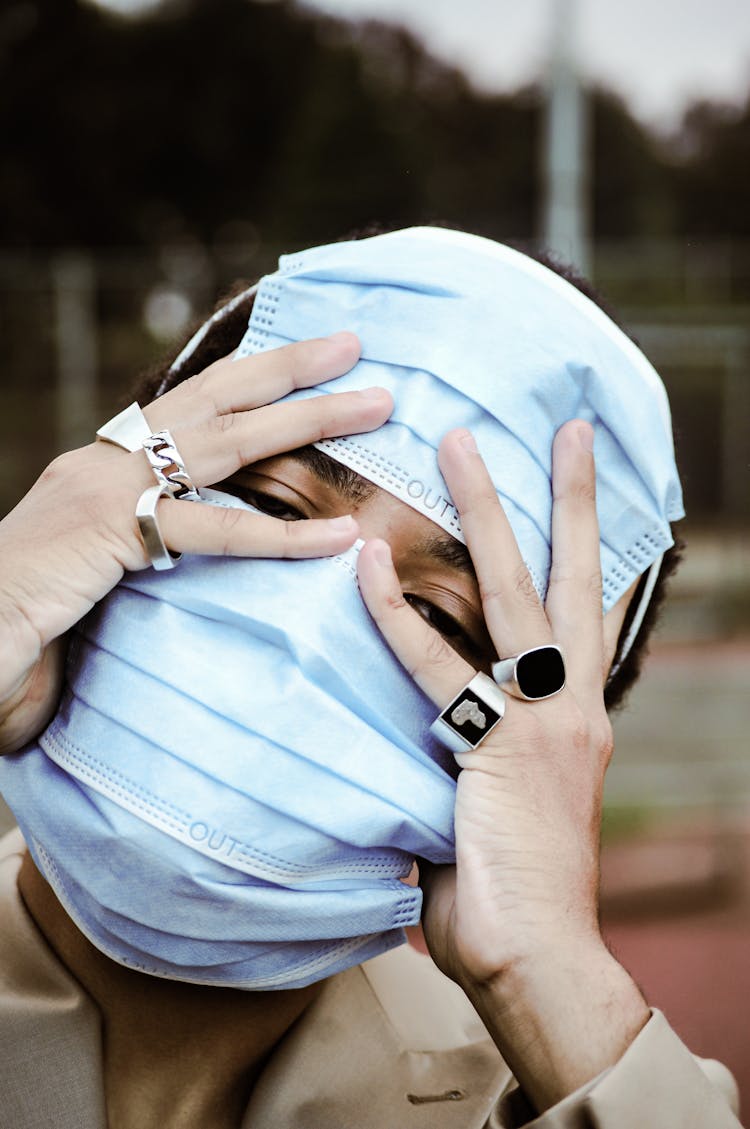 A Person Covering His Face With Surgical Masks