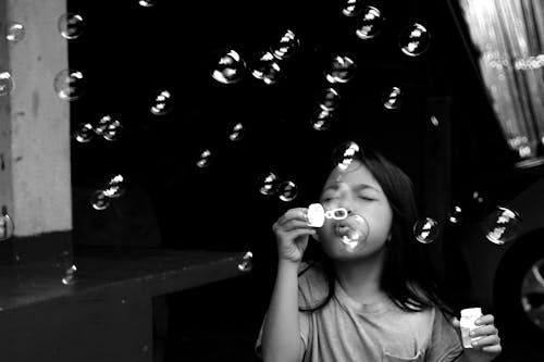 Free stock photo of black and white, blowing bubbles, children playing Stock Photo