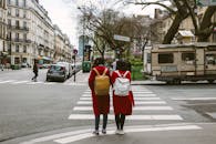 两名穿着红色外套的妇女在巴黎街道的斑马线上穿过