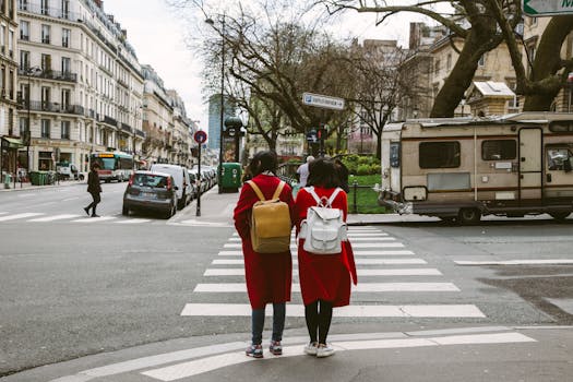 两名穿着红色外套的妇女在巴黎街道的斑马线上穿过