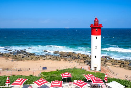 A Red and White Lighthouse on a Shore 