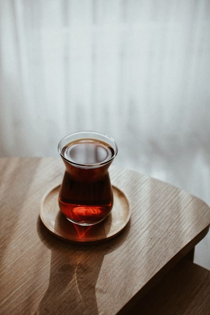 A serene scene of Turkish tea in a traditional glass on a wooden table, evoking tranquility.