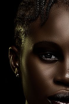 Striking close-up portrait highlighting the natural beauty and texture of a woman's skin under dramatic lighting.