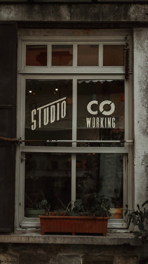 Free Vintage aesthetic window with coworking studio signage, evoking creativity. Stock Photo
