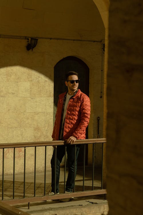 Stylish Man in Red Bubble Jacket and Black Sunglasses
