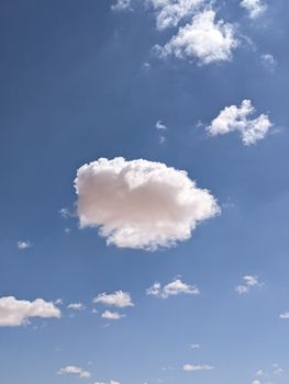 Serene image of blue sky featuring fluffy white clouds on a sunny day.