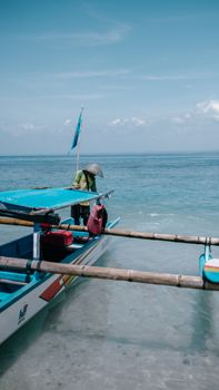 A traditional fishing boat docked along the shore in West Java, Indonesia, under a clear blue sky. - Fotografer Sidoarjo