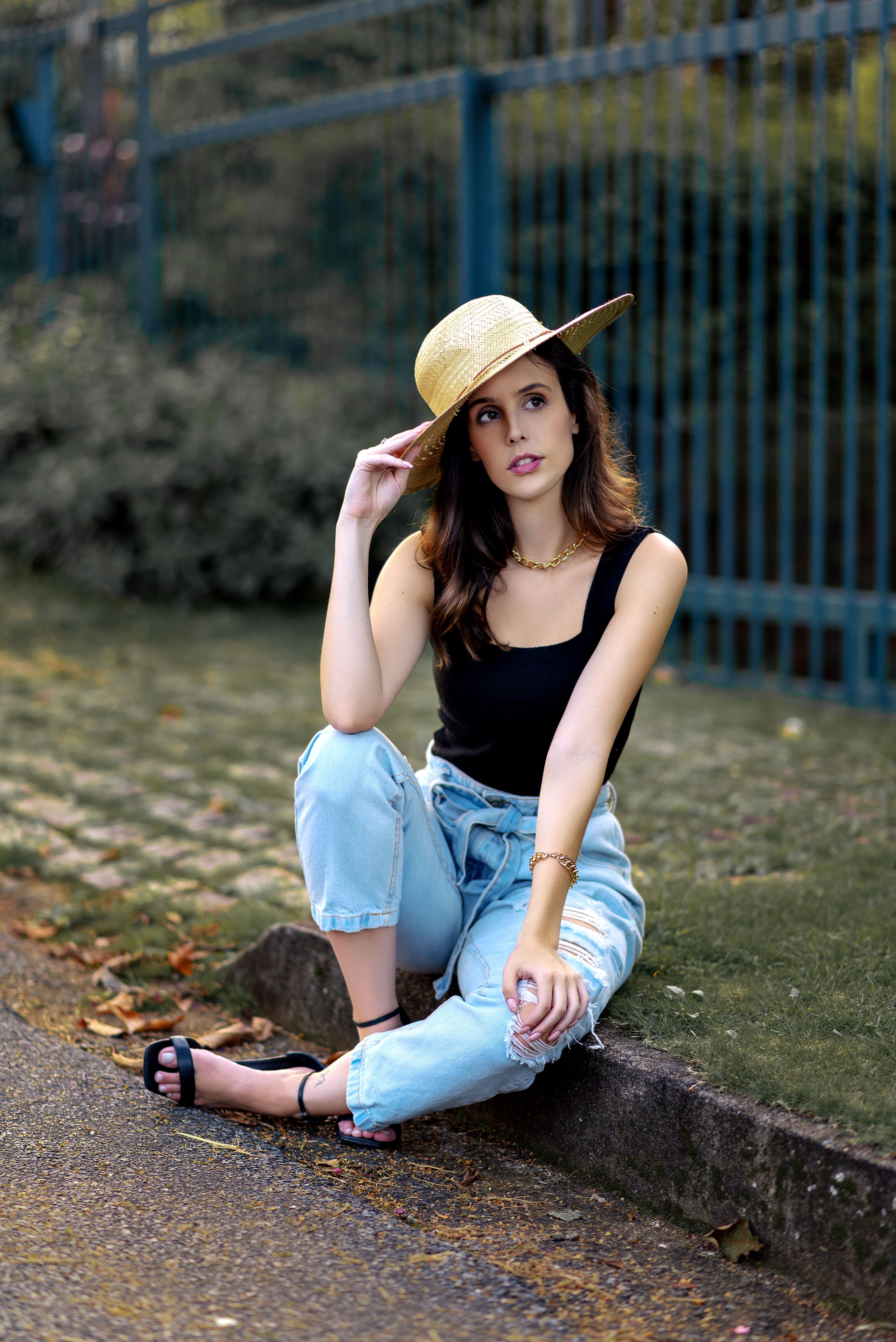 A Beautiful Woman in Black Tank Top and Denim Jeans Sitting on the ...