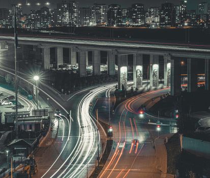 Captivating night cityscape of Istanbul featuring vibrant light trails under an illuminated bridge.