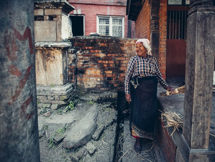 Smiling Old Woman Near Farm House