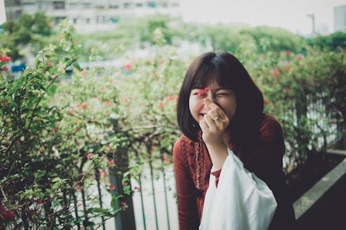 Woman Holding A Red Petaled Flower 