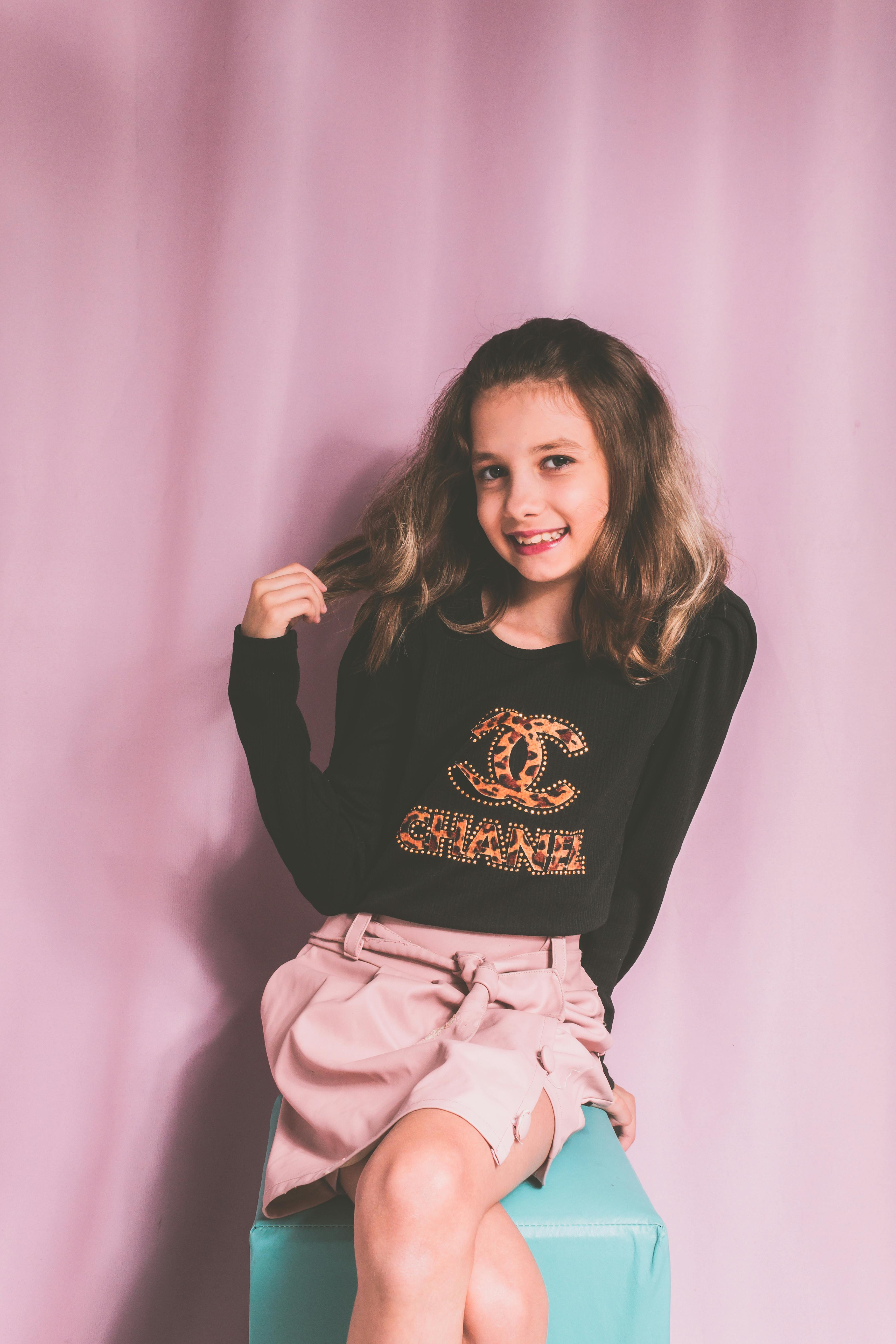 Young Girl Wearing Pink Dress Sitting on Shelves · Free Stock Photo