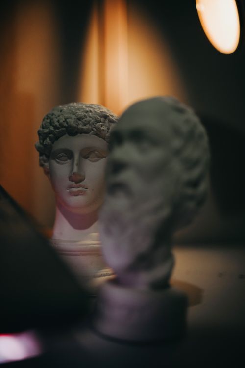 Free Intricate ceramic head busts in a moody, artistic display, uniquely illuminated to enhance detail. Stock Photo