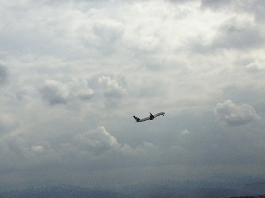Commercial airplane taking off from a French airport with a scenic landscape below