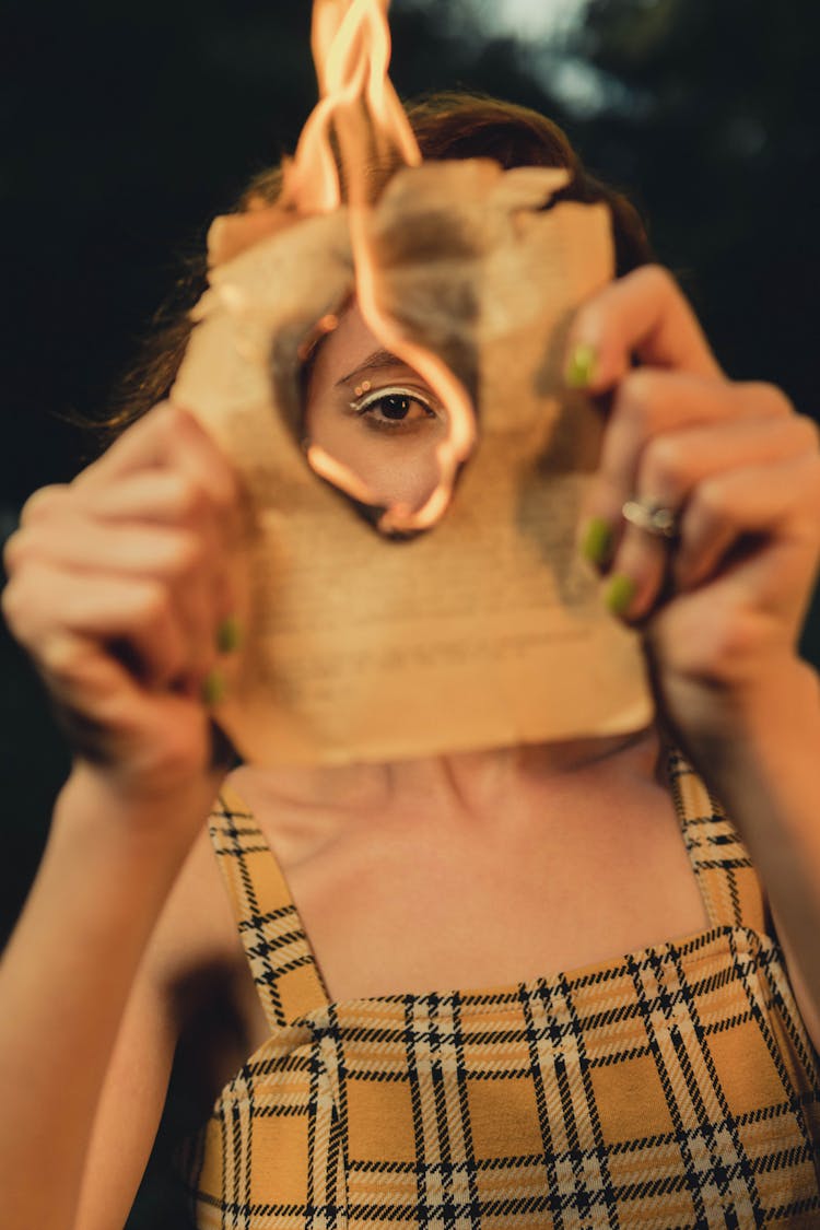 A Woman Holding A Burning Paper