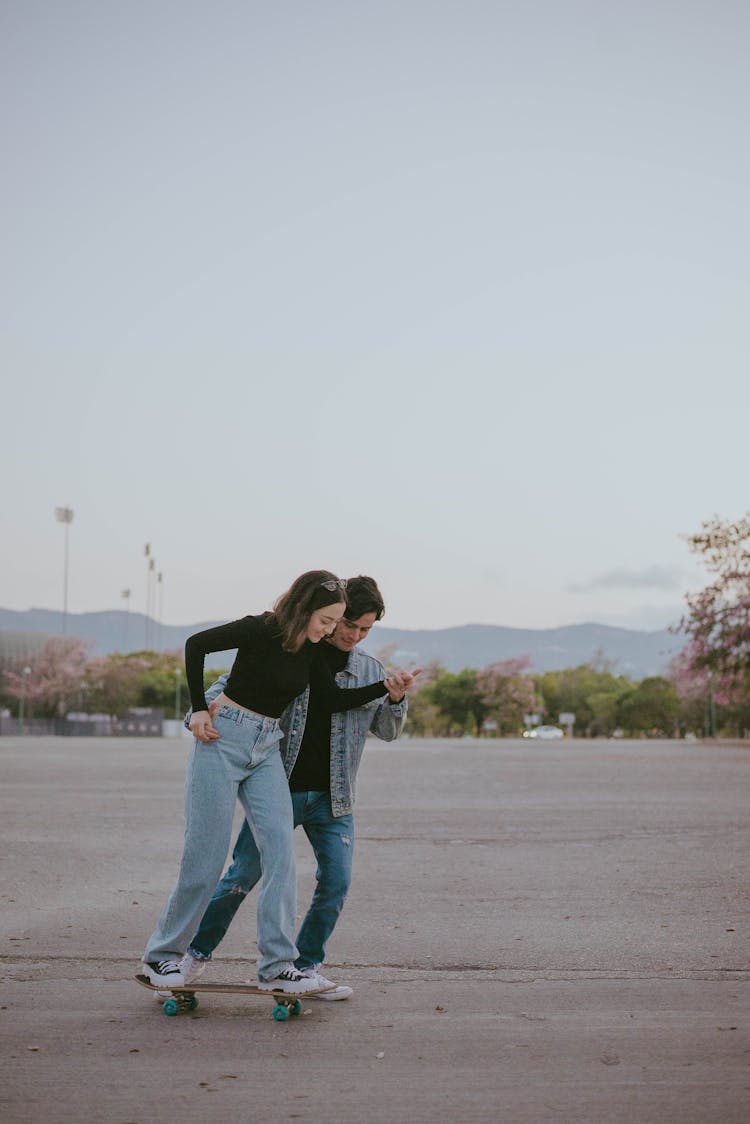 A Couple Skateboarding On The Street