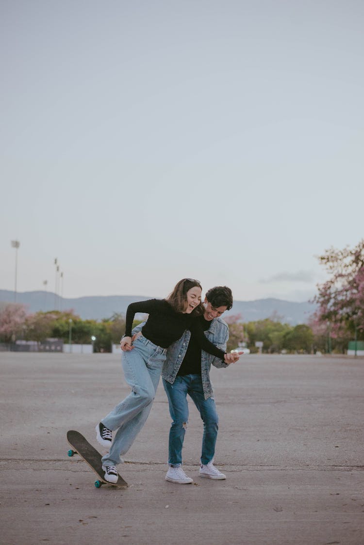 A Couple Skateboarding On The Street