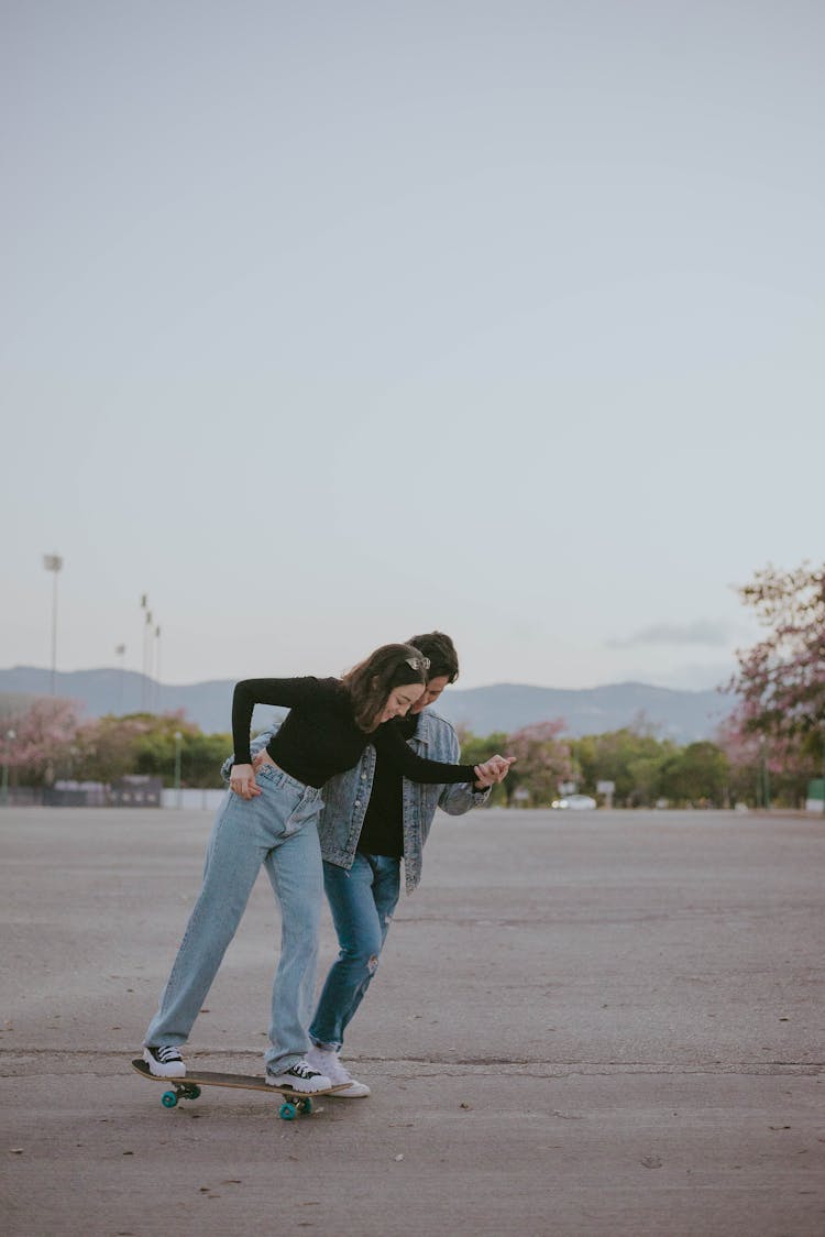 A Couple Skateboarding On The Street