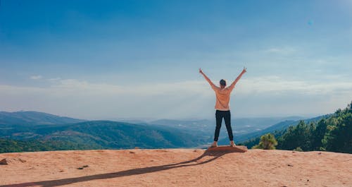 Free Person in Beige Top on Mountain Cliff Stock Photo