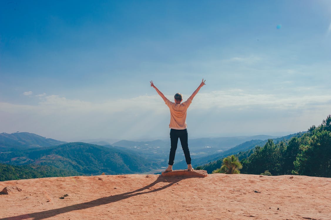 Free Woman Standing on Cliff Stock Photo