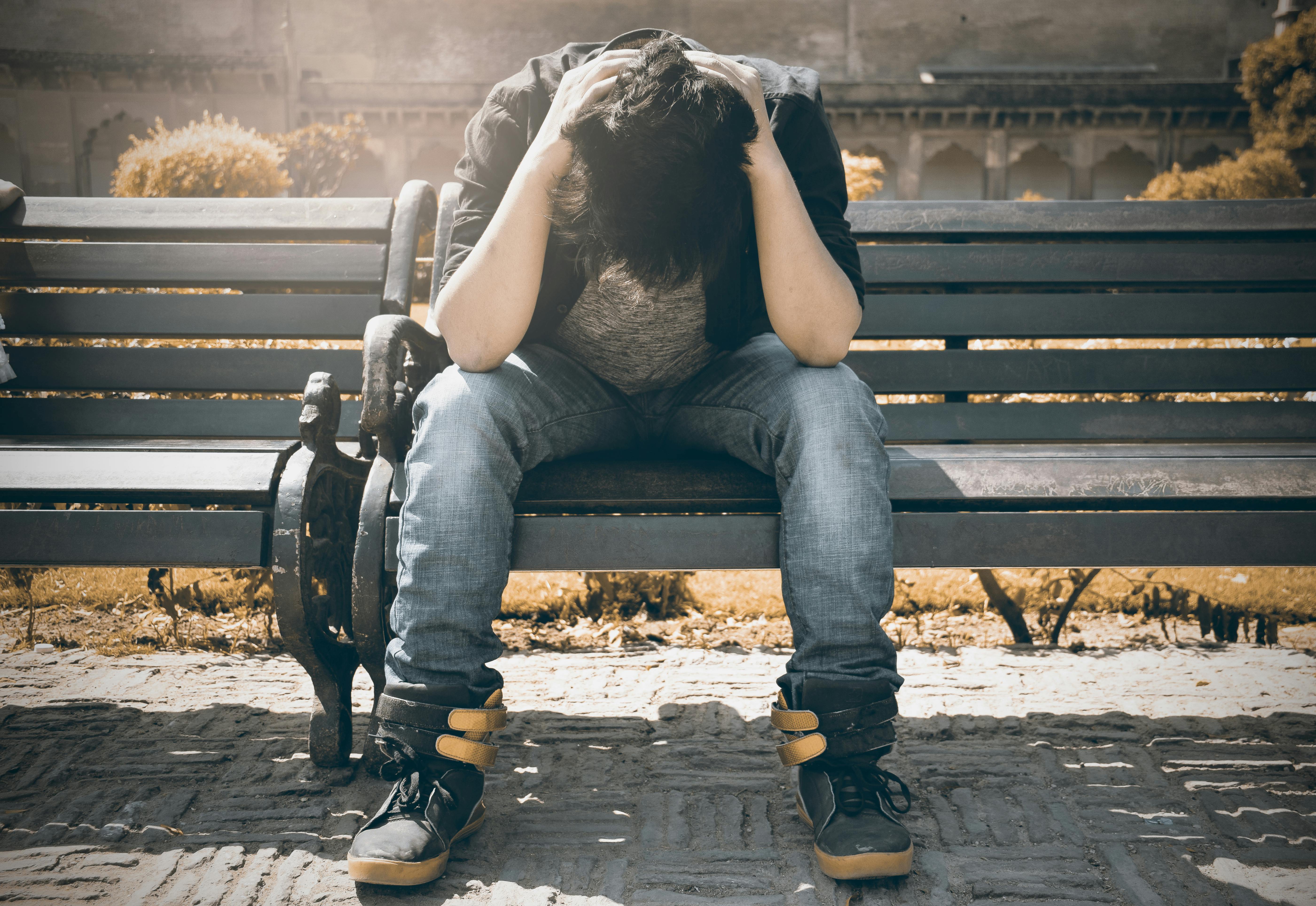 Man sitting on a bench. | Photo: Pexels