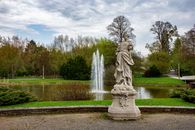 Brown Statue on Green Grass Field Under White Clouds