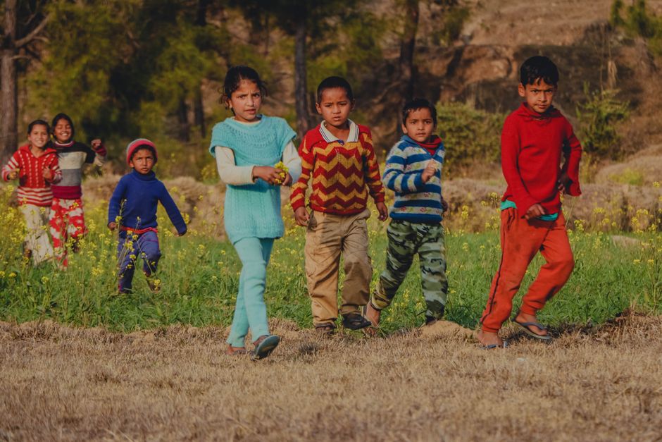 Un grupo de niños disfrutando del tiempo de juego en un campo vibrante, mostrando momentos despreocupados de la niñez.