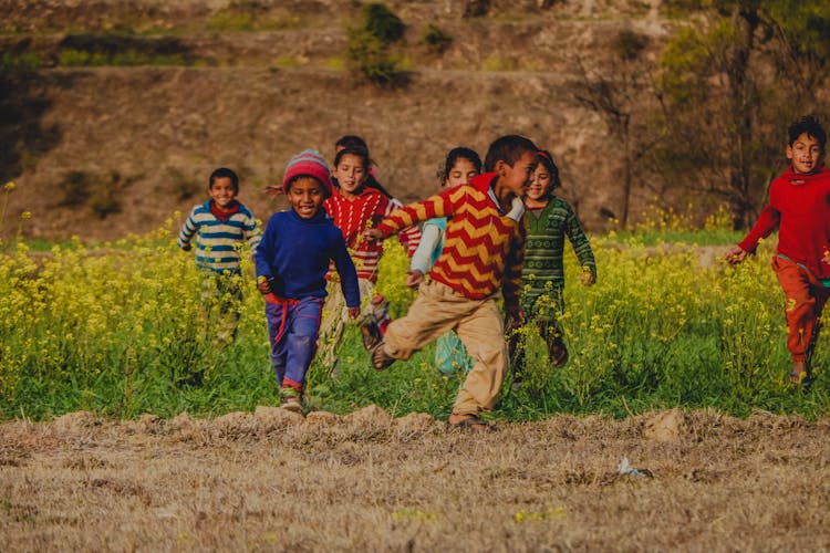 A Group Of Kids Running At The Field