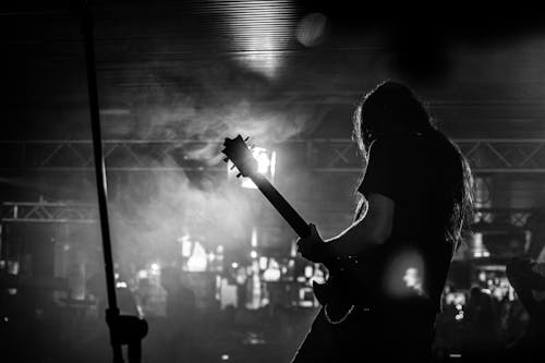 Grayscale Photo of a Person Playing Electric Guitar