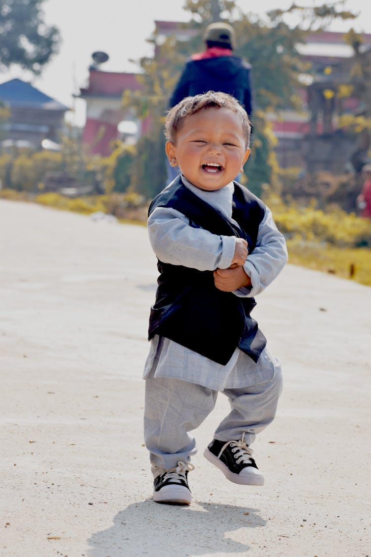 Happy Boy Walking Along Sidewalk