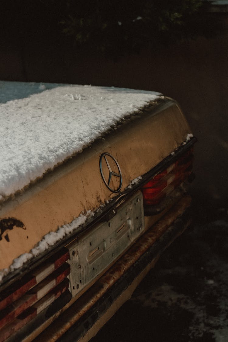 An Old Rusty Mercedes Benz Car Covered With Snow