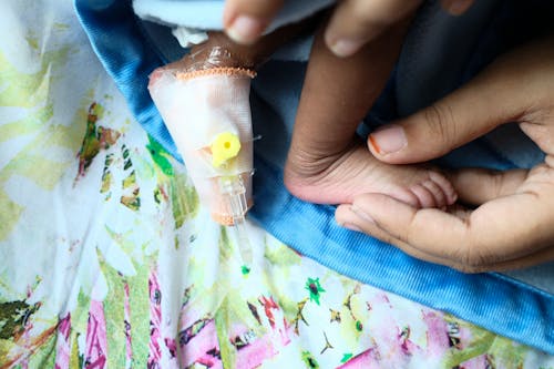 Free Fingers Holding Child Feet in Bandage Stock Photo