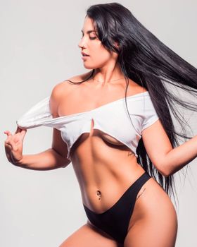 Stylish studio shot of a confident woman in fashionable attire, showcasing elegance and strength.