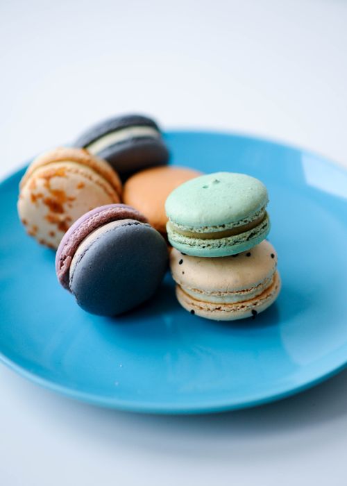 Free A colorful assortment of macarons displayed elegantly on a vibrant blue plate. Stock Photo