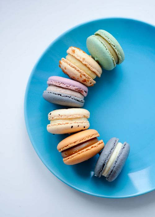 Free A vibrant display of assorted macarons on a blue plate with copy space. Stock Photo
