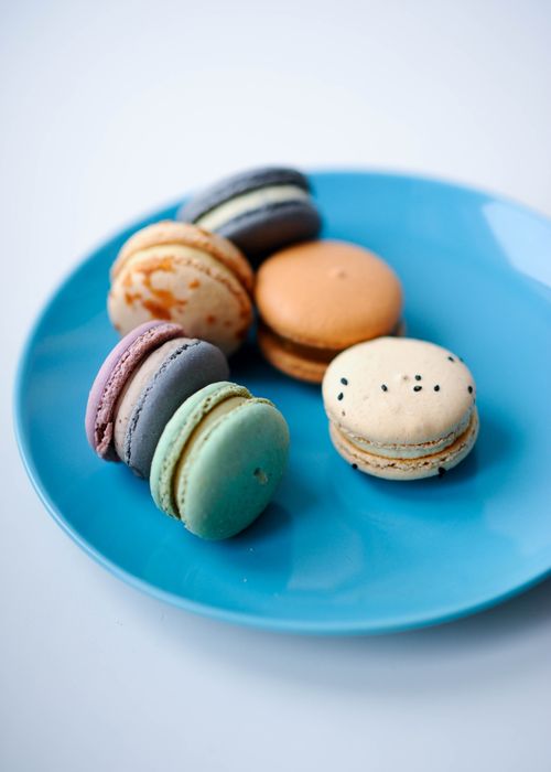 Free Vibrant French macarons arranged on a blue plate, showcasing a delightful assortment of colors. Stock Photo
