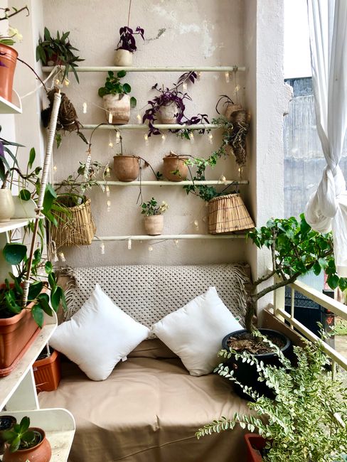 Charming balcony with cozy seating, potted plants, and decorative baskets for a serene outdoor space.