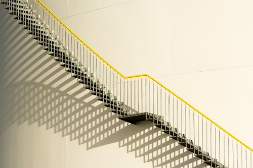 Free Diagonal staircase with striking shadows on a minimalist building facade. Stock Photo