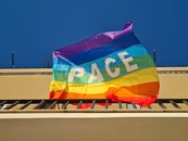 Colorful peace flag waving under a clear blue sky in Diamante, Calabria.