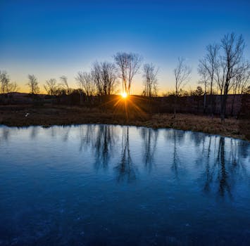 A tranquil winter sunrise reflecting over a frozen lake in Kellogg, Minnesota.