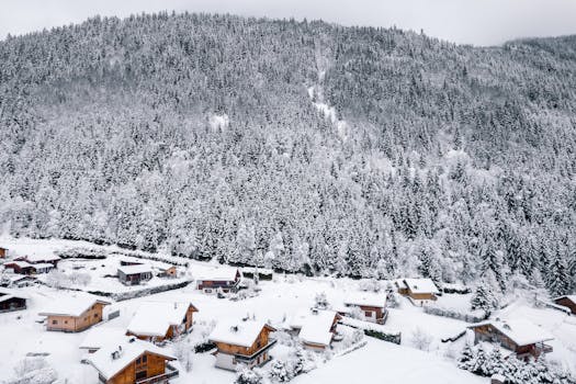 Charming snowy village nestled in snow-covered mountains of Les Contamines-Montjoie, France.
