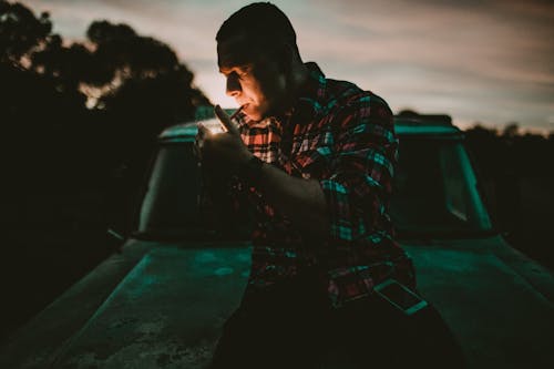 A Man in Plaid Long Sleeves Smoking Cigarette