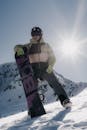 Snowboarder Standing on Snowy Slope in Mountains