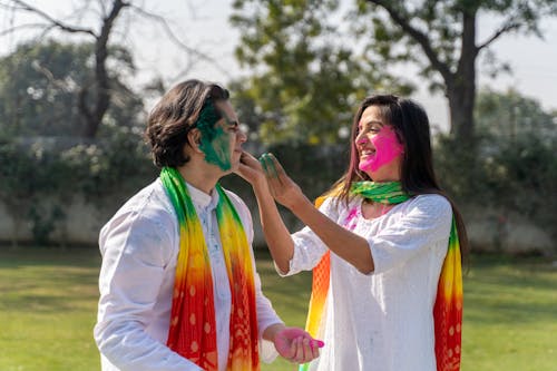 Free Man and Woman with Colorful Powder of Faces Stock Photo