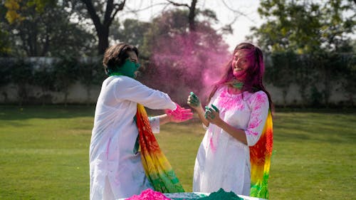 A Man and Woman Playing with Colorful Powder