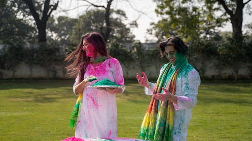 A Man and Woman Playing with Colorful Powder