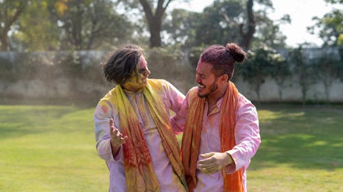 Men Having Fun with Colorful Powder on Their Faces