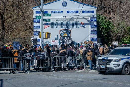 Protestors gather outside Rikers Island in New York City, advocating for prison reform.