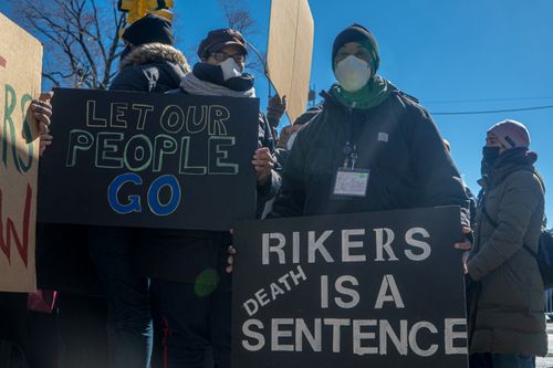 Free A group of activists protest in New York City with signs demanding changes at Rikers Island. Stock Photo